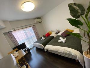 um quarto com duas camas e um vaso de plantas em Takemura Building 2nd floor em Tóquio