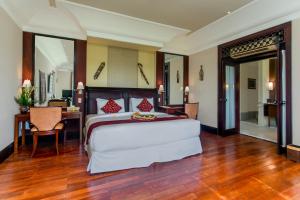 a bedroom with a large bed and a desk at Anhera Suite Ubud in Ubud
