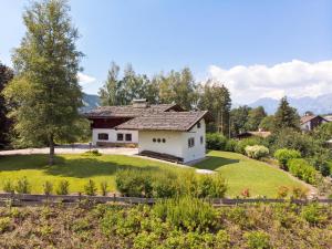 una casa en una colina con un patio verde en Villa Alpenblick en Kitzbühel