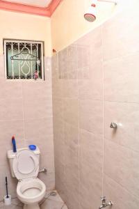 uma casa de banho com um WC e um chuveiro em Nice Spacious 1bedroom hideout in bamburi em Mombaça
