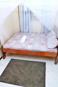 uma cama futon num quarto com um tapete em Nice Spacious 1bedroom hideout in bamburi em Mombaça