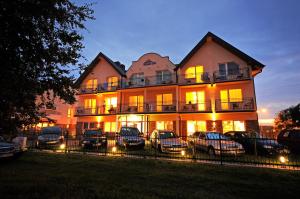 a large building with cars parked in front of it at Centrum Wypoczynku Victoria Spa in Grzybowo