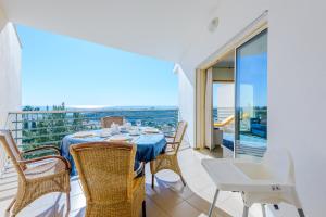 uma sala de jantar com mesa e cadeiras e uma varanda em Ocean view Apartment with 3 spacious Terraces, 2 Swimming pools & Tennis court em Albufeira