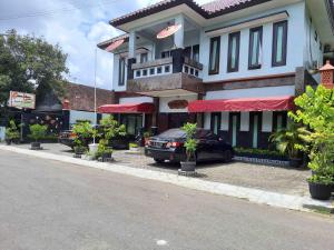 a black car parked in front of a building at Omahkoe Syariah Guesthouse RedPartner in Seturan