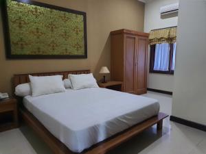 una camera con un grande letto bianco di Omahkoe Syariah Guesthouse RedPartner a Seturan