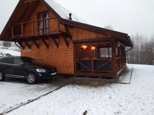 samochód zaparkowany na śniegu przed kabiną w obiekcie Domek na wzgórzu ''NIEDŹWIEDŹ'' w mieście Świątkowa Mała