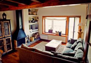ein Wohnzimmer mit einem Sofa und einem Kamin in der Unterkunft Casa 4 Habitaciones en Osseja in Osséja