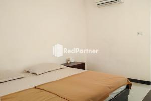 a bedroom with a bed with a laptop on it at Palu City Guest House Mitra RedDoorz in Palu