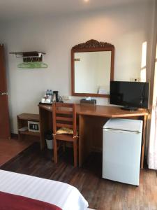 a desk with a television and a mirror in a room at Tong Mee House Hua Hin in Hua Hin