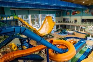 um grande parque aquático interior com um escorrega aquático em Noorus SPA Hotel em Narva-Jõesuu