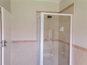 una ducha con puerta de cristal en un baño en Centurion Cosy Apartment, en Centurion 35 fotos más