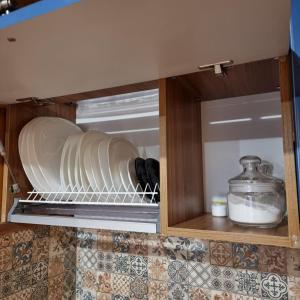 a cupboard with plates and a glass container in it at Guest House Viktoria&Vladimir in Novyy Svet