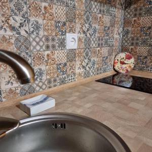 a bathroom sink with a faucet on a counter with tiles at Guest House Viktoria&Vladimir in Novyy Svet