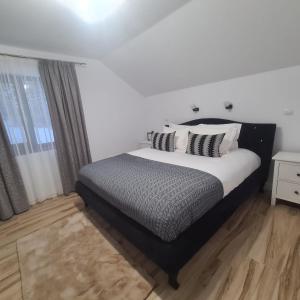 a bedroom with a large bed and a window at Casa Ardeluta in Ardeluţa