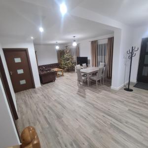 a living room with a table and chairs and a christmas tree at Casa Ardeluta in Ardeluţa