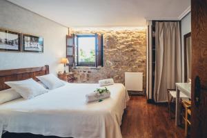 a bedroom with a large white bed and a window at Casa Rural Jesuskoa in Zumaia