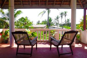 two chairs on a porch with a view of the ocean at The Calm Rest in Weligama