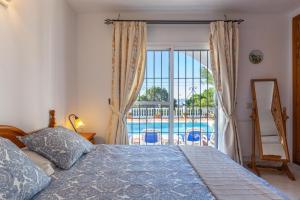 a bedroom with a bed and a view of a pool at Casa Pepe in Mijas +22 photos