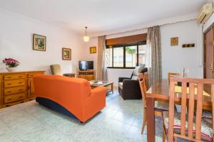 ein Wohnzimmer mit einem orangenen Sofa und einem Tisch in der Unterkunft Latina in La Cala del Moral