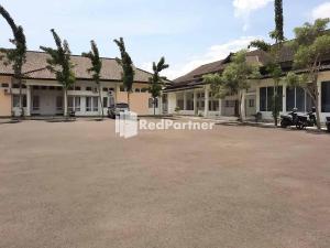 a building with a parking lot in front of it at Wisma Baznas Syariah Majalengka Mitra RedDoorz in Majalengka