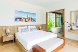 1 dormitorio con 1 cama grande y bañera en Ananas villa Shambala grand Cherng Talay en Bang Tao Beach