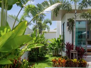 Ananas villa Shambala grand Cherng Talay في شاطئ بانغ تاو: منزل أمامه مجموعة من النباتات