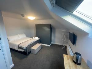 a small bedroom with a bed and a window at Arlan House, Central Basingstoke Hotel in Basingstoke