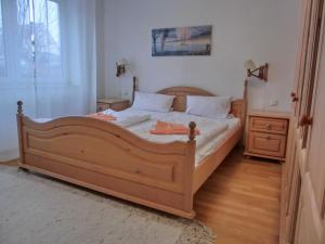 a bedroom with a large wooden bed and a window at Ferienwohnung R3 in Graal-Müritz
