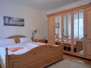 a bedroom with a bed and a wooden cabinet at Ferienwohnung R3 in Graal-Müritz +6 photos