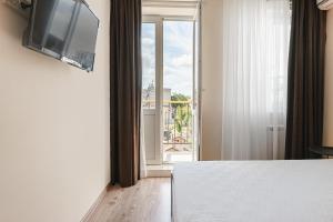 a room with a bed and a tv and a window at 20 Deribasivska 2 bedrooms Apartment in Odesa