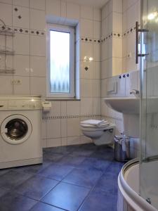 a bathroom with a toilet and a sink and a washing machine at Ferienwohnung R3 in Graal-Müritz