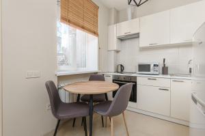 a kitchen with a table and chairs in a kitchen at 20 Deribasivska 2 bedrooms Apartment in Odesa
