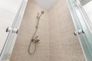 a shower with a shower head in a bathroom at 20 Deribasivska 2 bedrooms Apartment in Odesa +6 photos