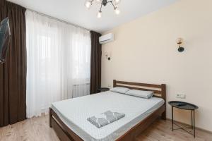 a bedroom with a bed and a large window at 20 Deribasivska 2 bedrooms Apartment in Odesa