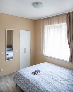 une chambre avec un lit, une fenêtre et un miroir dans l'établissement Chill&Go Apartment, à Kaunas