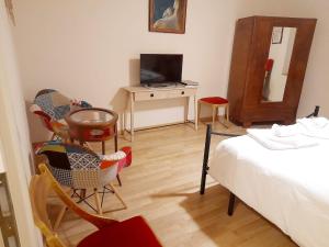 um quarto com uma cama e cadeiras e uma televisão em Appartamento Palma em Spello