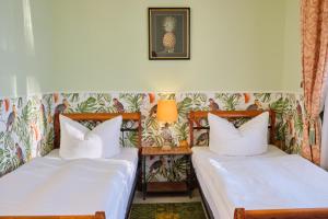 two twin beds in a room with a wall at Anno 1900 Hotel Babelsberg in Potsdam