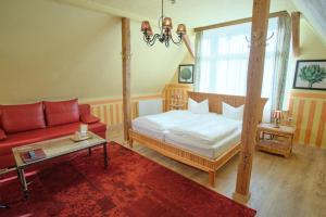 a bedroom with a bed and a red couch at Anno 1900 Hotel Babelsberg in Potsdam
