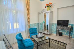 a living room with blue chairs and a mirror at Anno 1900 Hotel Babelsberg in Potsdam