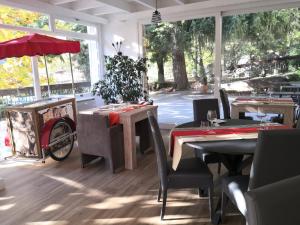 a dining room with tables and chairs and windows at Logis Hôtel-Restaurant Le Tanargue in Valgorge