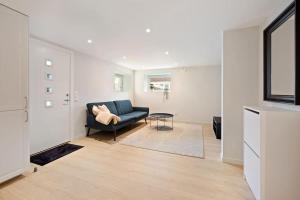 a living room with a blue couch and a table at Practical Basement Apt with all home comforts close to City Centre in Stavanger