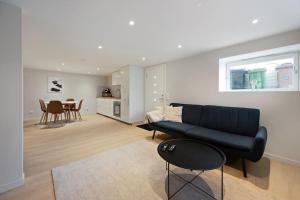 a living room with a black couch and a table at Practical Basement Apt with all home comforts close to City Centre in Stavanger