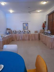 a room with tables and chairs in a room at Hotel Amisa Golf Course Road MG Road in Gurgaon