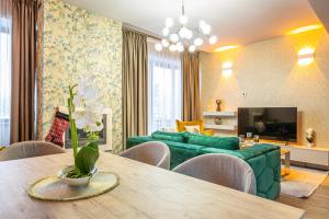 a living room with a green couch and a table at Kron luxury 2 Bedroom Apartment in Silver Mountain in Poiana Brasov