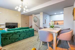 a living room with a green couch and a table at Kron luxury 2 Bedroom Apartment in Silver Mountain in Poiana Brasov