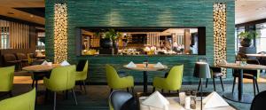 a restaurant with tables and chairs and a bar at Van der Valk Hotel Gilze-Tilburg in Tilburg