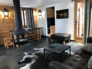 ein Wohnzimmer mit einem Sofa und einem Kamin in der Unterkunft Meribel Altitude1600 accès direct aux pistes 6 personnes in Méribel