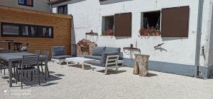 a patio with chairs and tables and a building at Hoeve Korenzegen. Oase van rust dichtbij strand in De Haan