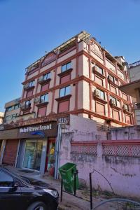 a building on a street with a car parked in front at Hotel Riverfront in Ahmedabad