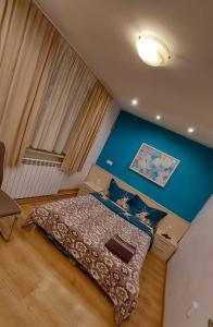 a bedroom with a bed and a blue wall at Libera in Sofia